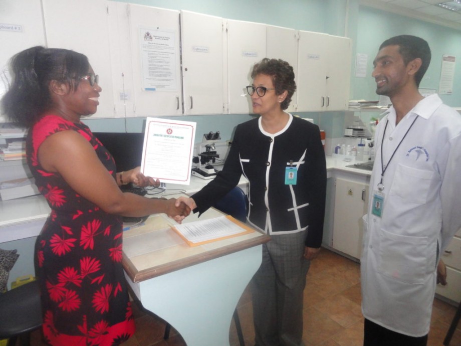 Ms. Evadnie Enniss at (left) hands offer the certificate to Dr. Madhu Singh