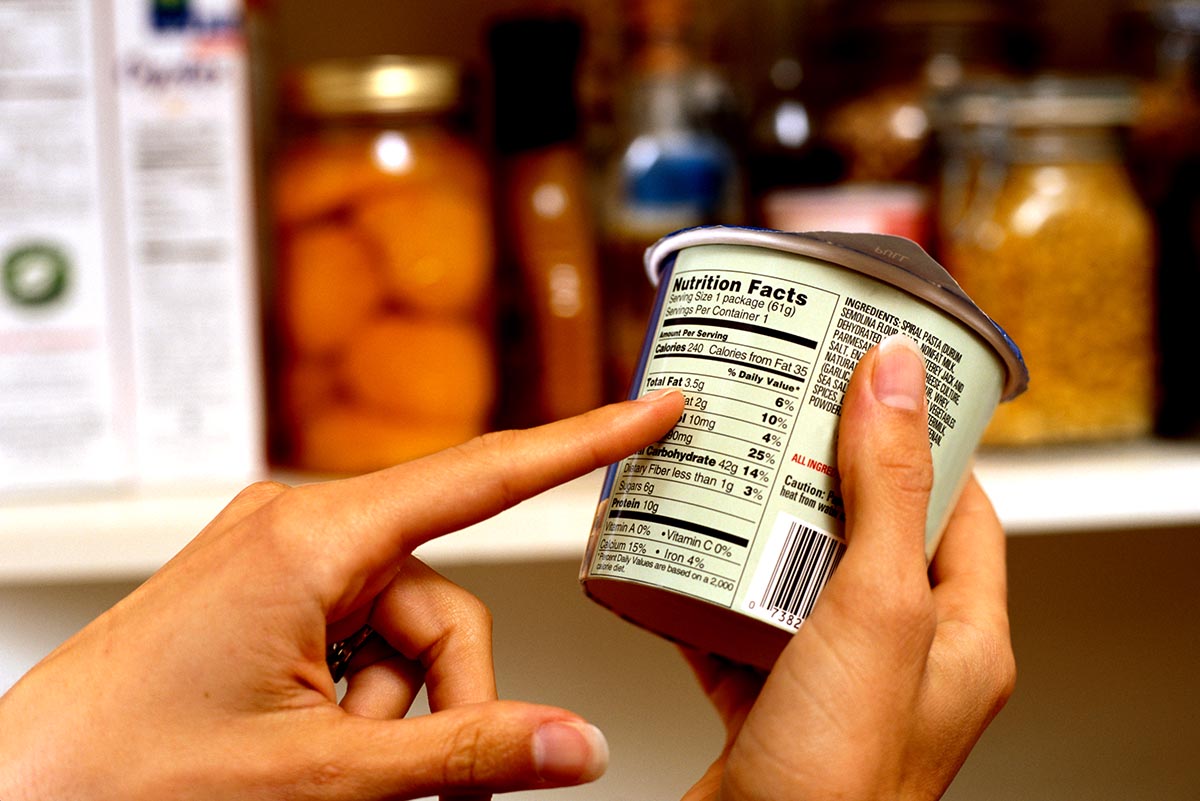 Person Reading Nutrition Label on Packaged Food